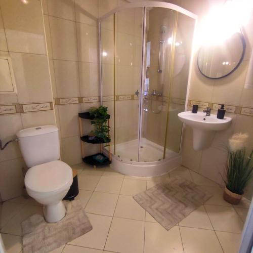 a bathroom with a toilet and a shower and a sink at Апартамент FLAME in Sunny Beach