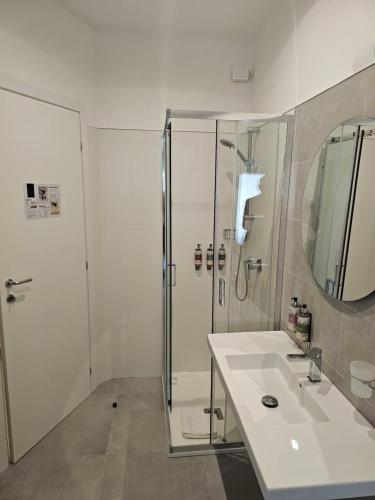 a white bathroom with a shower and a sink at Massimi City Garden in Rome