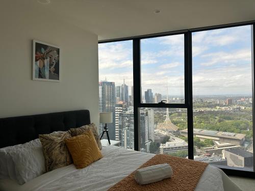 a bedroom with a bed with a view of the city at Skyline Serenity Retreat in Melbourne