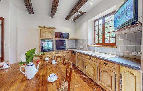 une cuisine avec des armoires en bois et une table en bois dans l'établissement Beautiful Home In Couhe, à Couhé-Verac