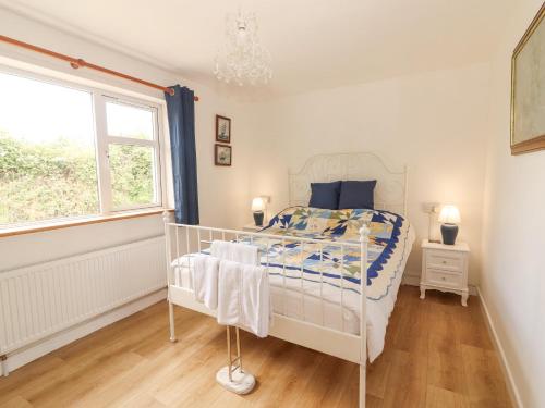 a bedroom with a white bed and a window at White Cottage in Abbeyfeale