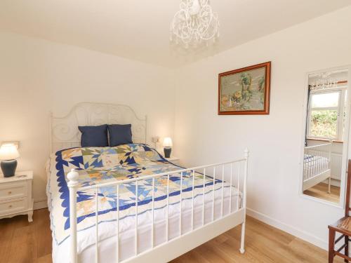 a bedroom with a white bed and a chandelier at White Cottage in Abbeyfeale