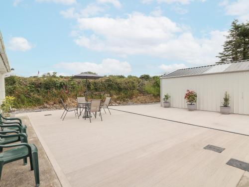 a patio with a table and chairs on it at White Cottage in Abbeyfeale