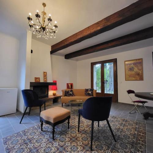un salon avec un canapé, des chaises et un lustre dans l'établissement La grange du Luberon, à Bonnieux