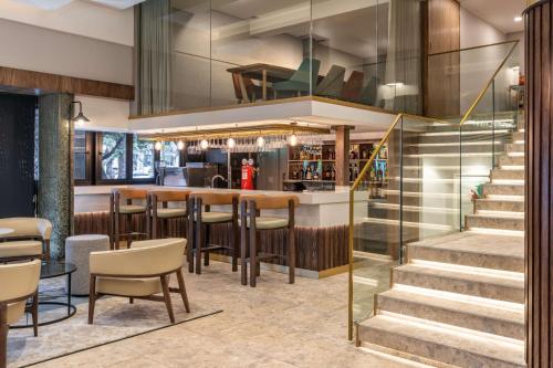 a bar in a restaurant with stairs and chairs at Radisson Hotel Cape Town Foreshore in Cape Town