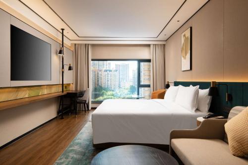a hotel room with a large bed and a tv at Hilton Garden Inn Beijing West Railway Station in Beijing