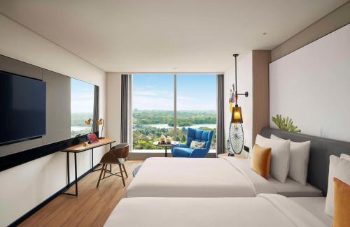 a hotel room with a bed and a flat screen tv at Hyatt Centric Hebbal Bengaluru in Bengaluru