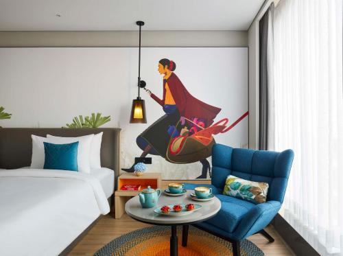 a bedroom with a bed and a blue chair at Hyatt Centric Hebbal Bengaluru in Bengaluru