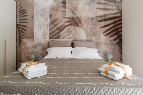 una camera da letto con un letto con asciugamani sopra di Mary House by BarbarHouse a Taranto