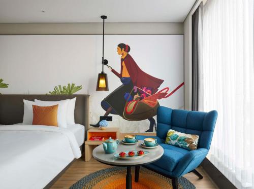 a bedroom with a bed and a blue chair at Hyatt Centric Hebbal Bengaluru in Bengaluru