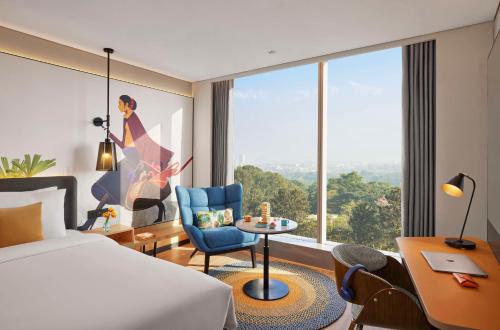 a hotel room with a bed and a large window at Hyatt Centric Hebbal Bengaluru in Bengaluru