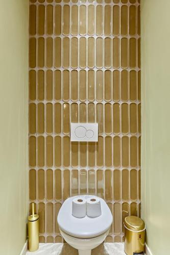 La salle de bains est pourvue de toilettes et d'un mur. dans l'établissement Incredible AC Apartment 3 bedrooms Center of Paris by Studio Prestige, à Paris