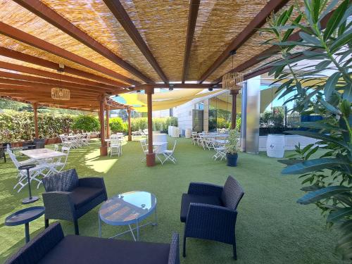 a covered patio with chairs and tables and a table at Amura Alcobendas in Alcobendas
