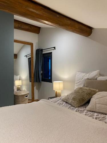 une chambre avec un lit blanc et un miroir dans l'établissement Appartement Brévent, aux Houches