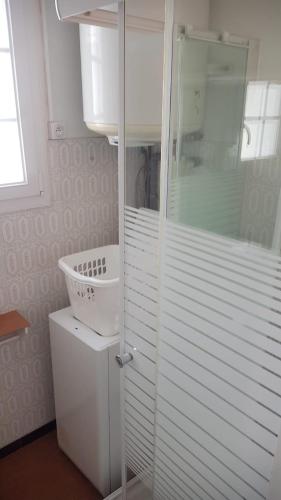 une salle de bain blanche avec une douche et un lavabo dans l'établissement Maison Madoret 6 personnes, à Saint-Hilaire-de-Riez