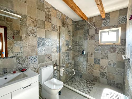 a bathroom with a shower and a toilet and a sink at Casa de Aloe in Albufeira