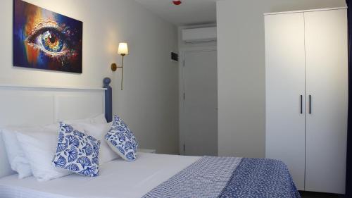 a bedroom with a bed with blue and white pillows at Cemile Hanım Konağı in Cesme