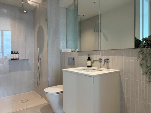 a bathroom with a sink and a toilet and a shower at Skyline Serenity Retreat in Melbourne