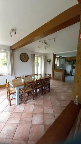 une salle à manger avec une table et des chaises dans l'établissement Gîte de la ferme d'Hougerville, à Colleville