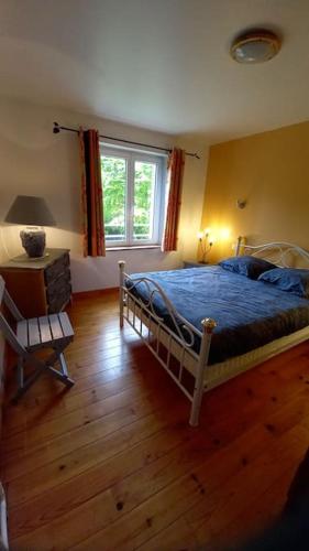 une chambre avec un lit et un parquet dans l'établissement Gîte de la ferme d'Hougerville, à Colleville