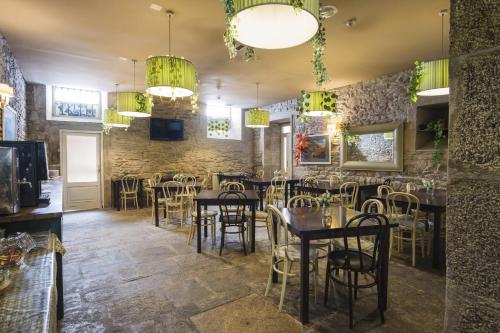 Un restaurante con mesas y sillas en una sala. en Hotel Alda Avenida, en Santiago de Compostela
