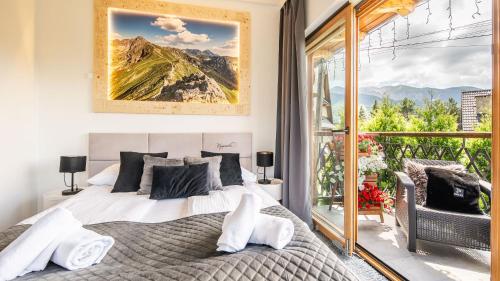 a bedroom with a bed and a large window at Aparthotel Delta Boutique in Kościelisko