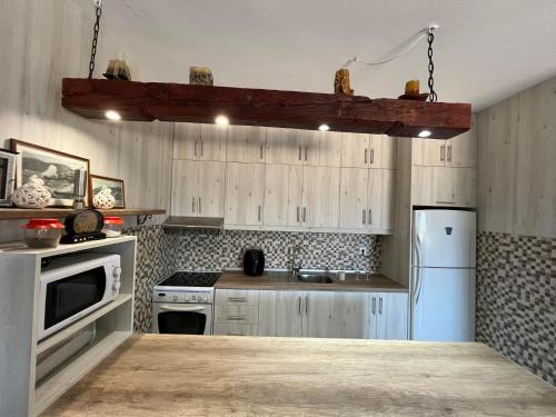 a kitchen with wooden cabinets and a white refrigerator at Eleni's country house in Karpathos Town