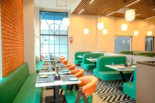 a dining room with tables and green chairs at Narayani Executive in Tuljapur