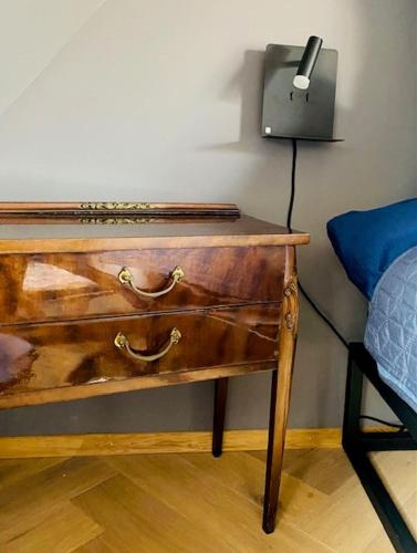 a wooden desk with a lamp next to a bed at Vintner Suites in Neustadt an der Weinstraße
