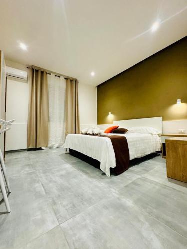 a bedroom with a bed and a yellow wall at Affitta camere Marsala L'oasi delle saline in Marsala
