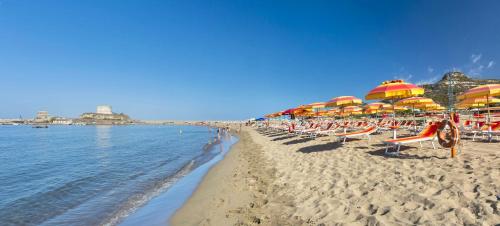 a sandy beach with umbrellas and chairs and the ocean at Residence with private beach in Bosa Marina just 100 meters from the sea in Bosa Marina