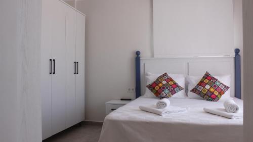 a bedroom with a white bed with two pillows at Cemile Hanım Konağı in Cesme
