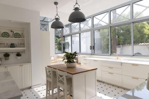 a kitchen with white cabinets and a table with a potted plant at Beach front Villa Cap D'Antibes in Antibes