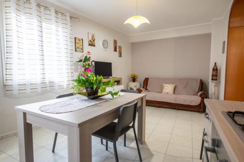 una cucina e un soggiorno con un tavolo e un divano di Casa Josy a Francavilla di Sicilia