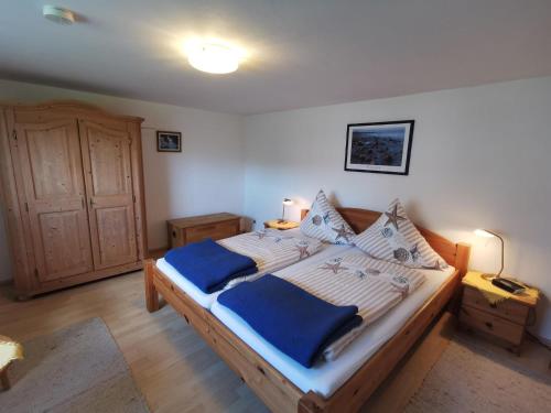 a bedroom with a bed with a blue blanket on it at Ferienwohnung Valentin in Glücksburg