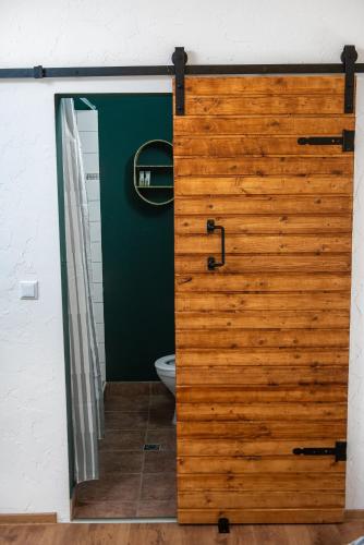 a wooden door in a bathroom with a toilet at LaWanda9 in Vama Veche