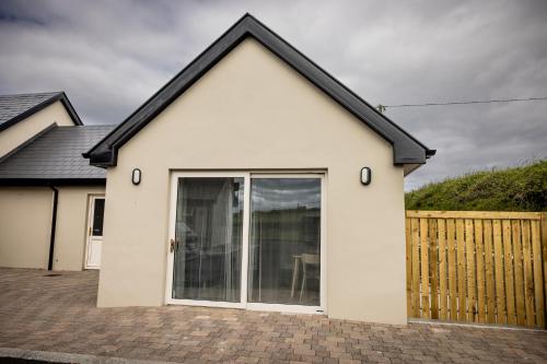 a white house with a large sliding door at Cahermaclanchy House in Doolin