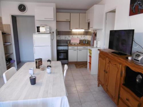 une cuisine avec une table et une télévision. dans l'établissement Appartement T2, 28m², Proche Plage, 4 Pers., Parking Privilégié à Narbonne Plage - FR-1-795-10, à Narbonne