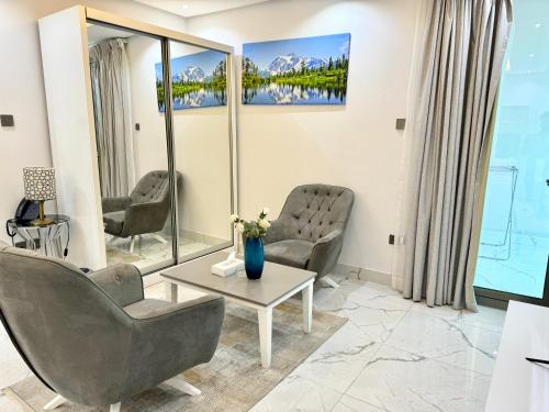 a waiting room with two chairs and a table at Al Safwa One in Al Ḩadd