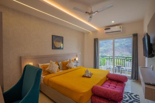 1 dormitorio con cama amarilla, mesa y sillas en Perfectstayz Value Alpine Retreat, en Rishīkesh