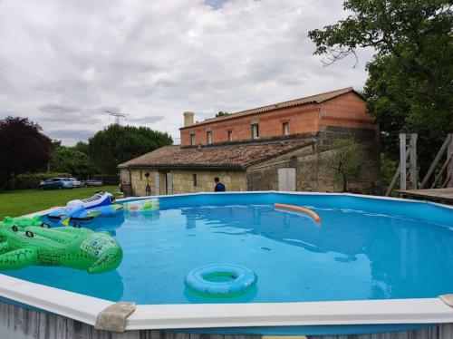 une grande piscine avec un crocodile en jouet et des tubes gonflables dans l'établissement Grande maison au calme, à Saint-André-de-Cubzac