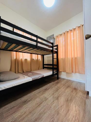 two bunk beds in a room with a wooden floor at Wyll's House in Dipolog