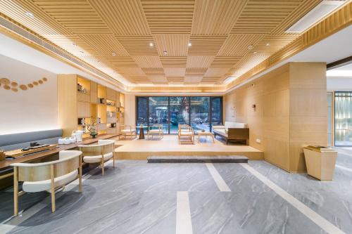 a living room with a table and chairs at Jianguo Puyin Hotel - Xi'an Big Wild Goose Pagoda University of Science and Technology Qujiang Campus Metro Station in Xi'an