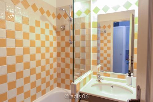 La salle de bains est pourvue d'une baignoire, d'une douche et d'un miroir. dans l'établissement Un Studio de Charme Vue Mer & Piscine d'Exception, à Cannes