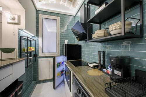 a kitchen with green tiles on the wall and a refrigerator at Rb Suites centrale in Trapani