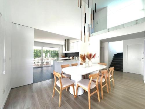 a dining room with a white table and chairs at Casa Charli Lisboa-Piscine chauffée en option in Aroeira