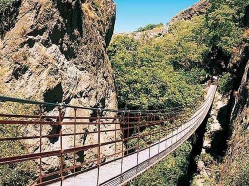 a suspension bridge on a mountain in a canyon at Evaleta 2, precioso apartamento recién estrenado in Monachil