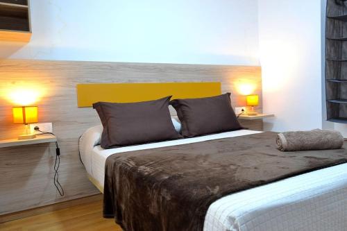 a bedroom with a large bed with two lamps at Evaleta 2, precioso apartamento recién estrenado in Monachil