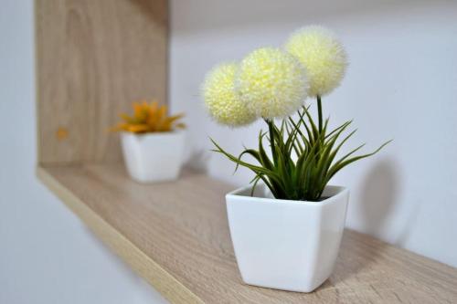 three flowers in a white vase on a table at Evaleta 2, precioso apartamento recién estrenado in Monachil