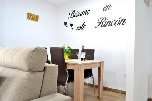 a table with a bottle of wine and two chairs at Evaleta 2, precioso apartamento recién estrenado in Monachil